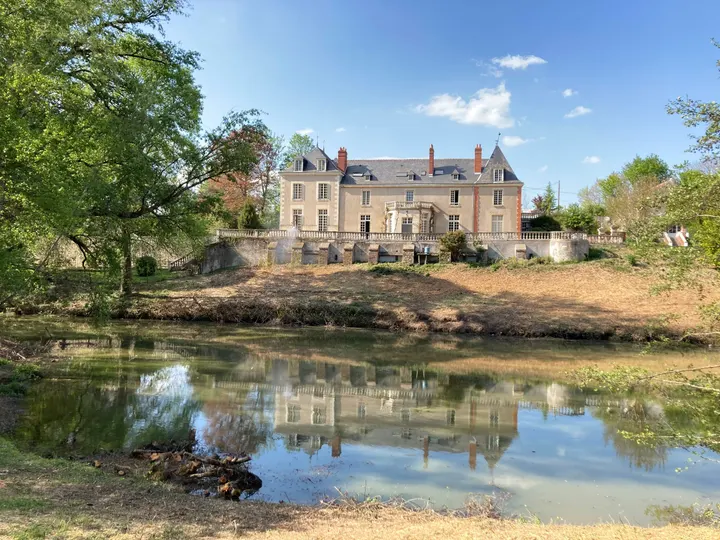 The château seen from the far side of the pond, summer sky